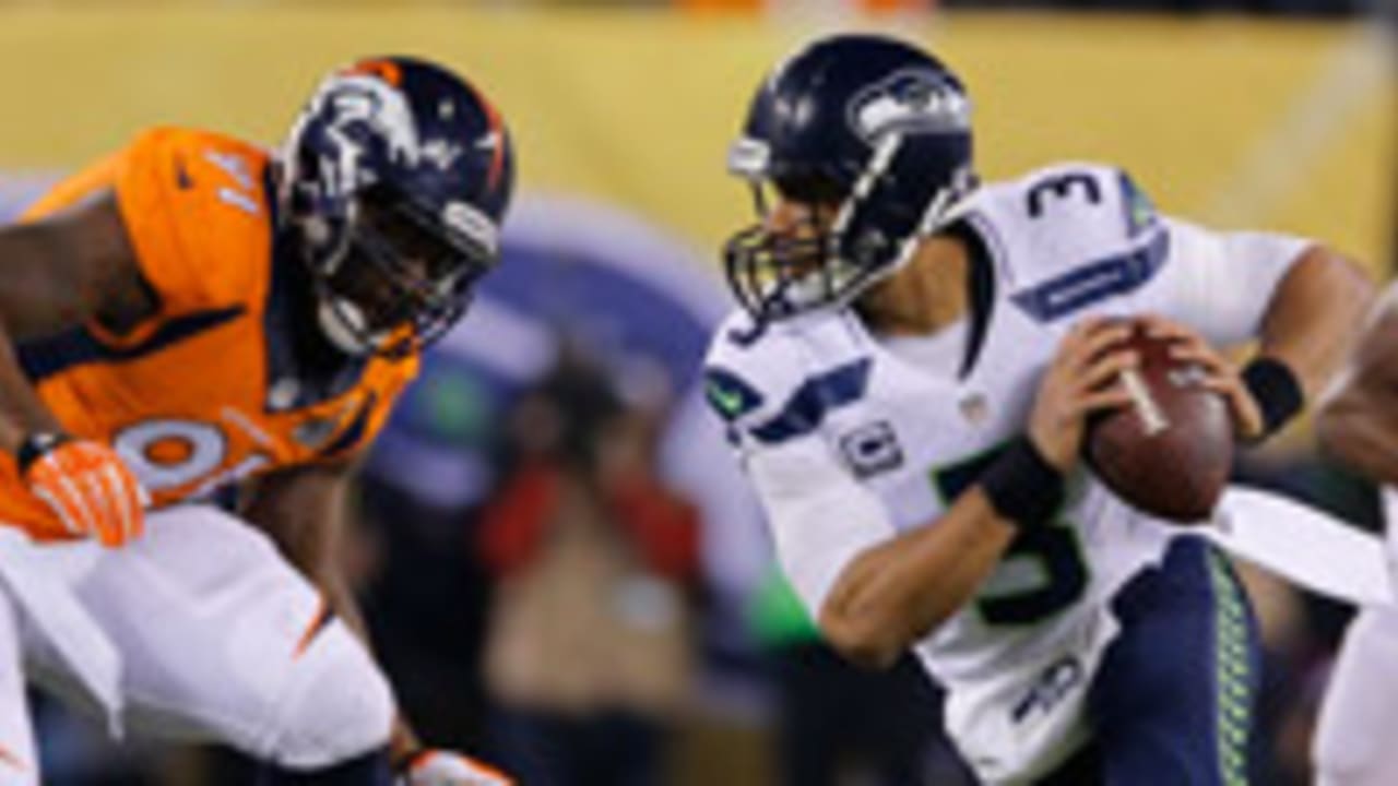 Denver Broncos wide receiver Vance Johnson (82) is tackled by Seattle  Seahawks Darrin Miller (9 …