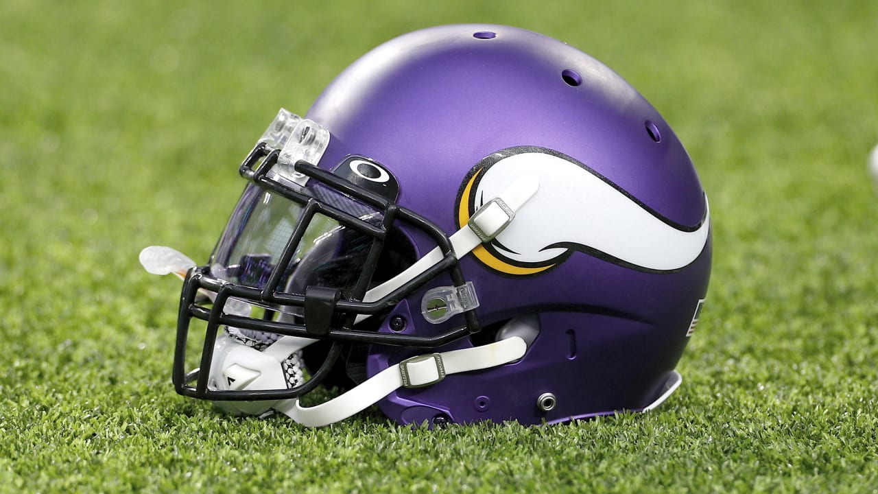 A Minnesota Vikings fan holds up a helmet with a pink ribbon on it as he  watches an NFL football game between the Vikings and the Kansas City Chiefs  Sunday, Oct. 2