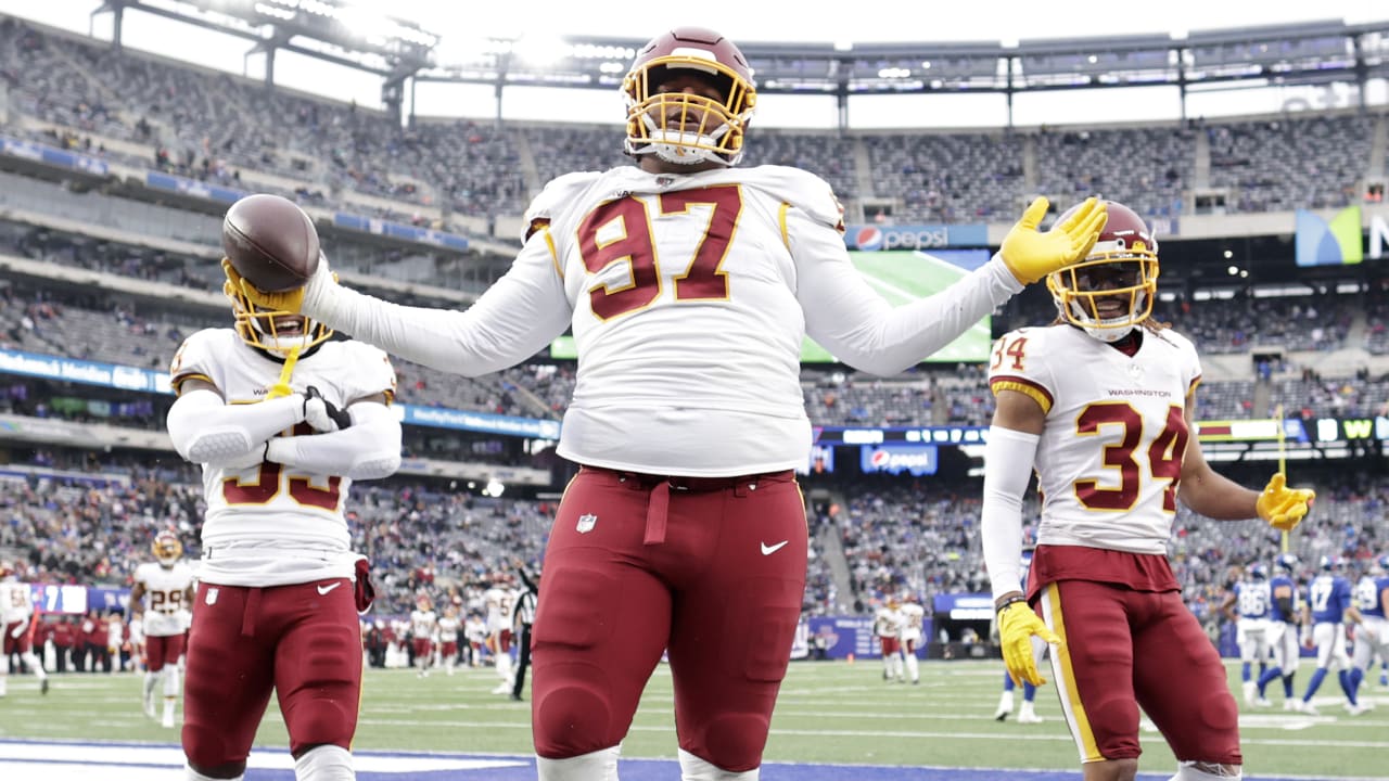 Washington Football Team defensive tackle Tim Settle is grabbed by