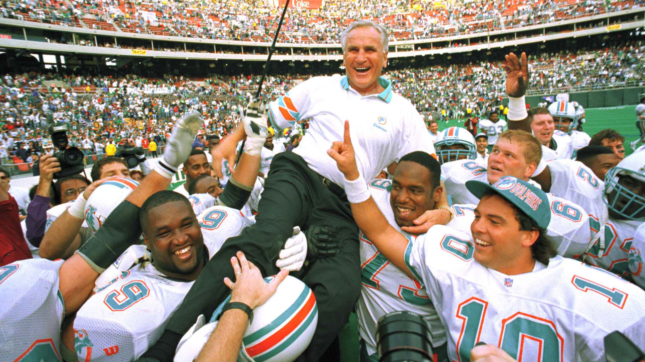 FILE - Former Miami Dolphins 1972 players Bob Griese (12) and Earl Morrall  (15) enjoy a half time celebration honoring the 1972 undefeated team at an  NFL football game against the Jacksonville