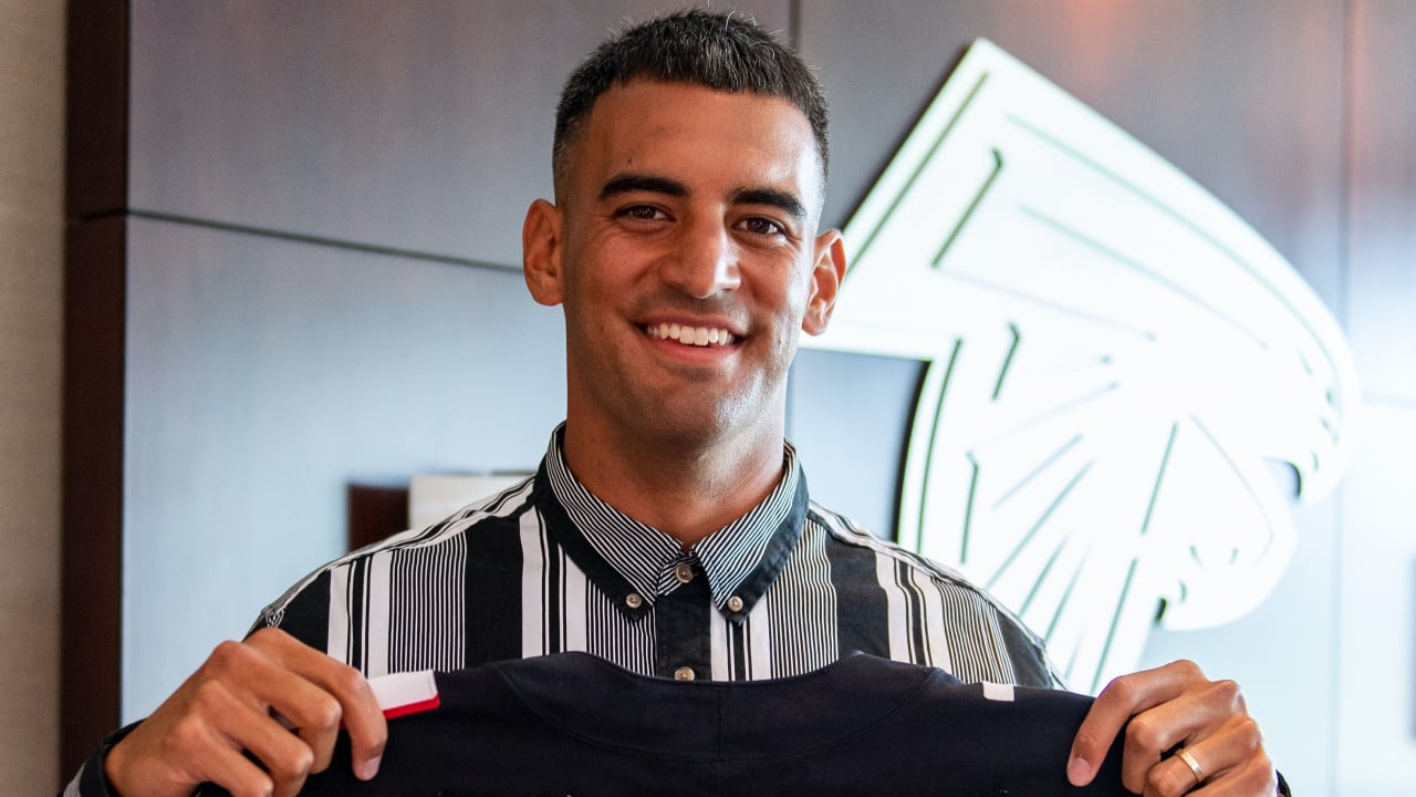 First look: Atlanta Falcons newly signed quarterback Marcus Mariota holding  his Falcons jersey, speaking with media