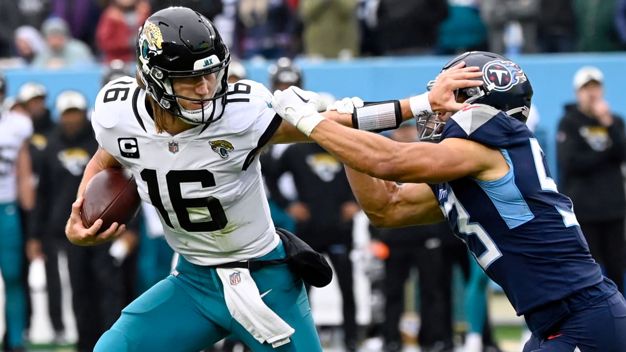 Jacksonville Jaguars quarterback Trevor Lawrence stiff-arms defender on
