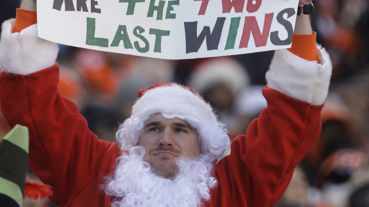 Jake Denooy of Fort Collins, Colo., places a Denver Broncos flag to top off  a Christmas tree while he tailgates before the Oakland Raiders face the  Broncos in the first quarter of