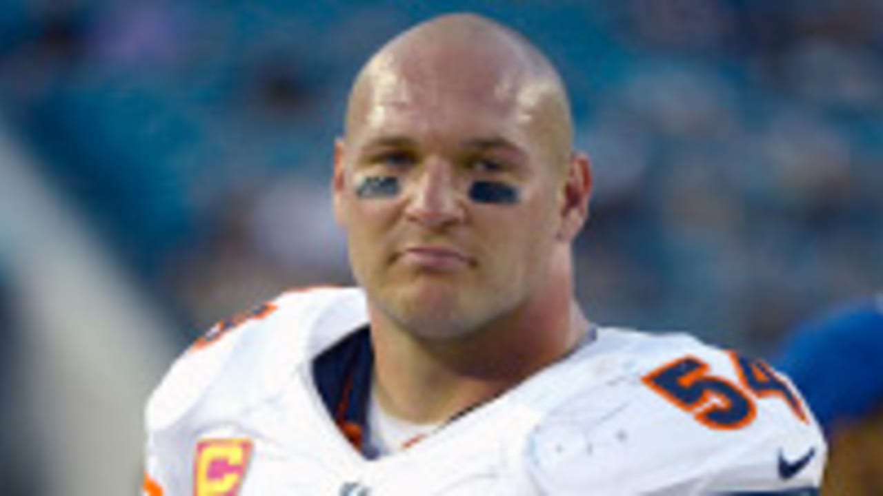 Former New Mexico and Chicago Bears football player Brian Urlacher applauds  on the field as his jersey number is retired during a halftime ceremony at  an NCAA college football game against Air