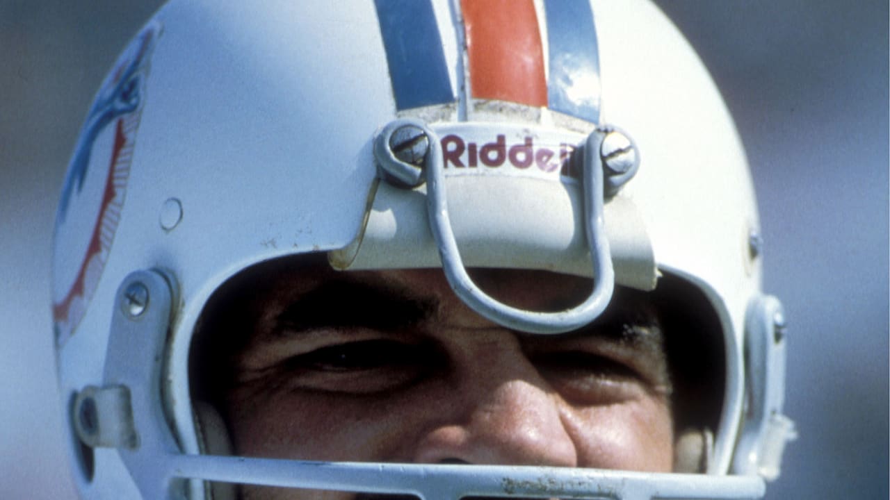 Running back Larry Csonka, in a flowery shirt, listens to ex-teammate Mercury  Morris as he sits on the bench at Miami's Orange Bowl, Aug. 17, 1975, to  watch the Dolphins beat the