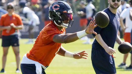 Chicago Bears quarterback Justin Fields signs baby's Bears jersey at  training camp