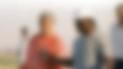 New York Giants linebacker Lawrence Taylor gestures towards head coach Bill Parcells before the start of a lite workout at Scottsdale Community college in afternoon on Monday, Nov. 6, 1989 in Scottsdale.  The only worked out about 15 minutes and will have the day off Tuesday. They will practice this week in Arizona before to Los Angeles and their Sunday game with the Rams  (AP Photo/Jeff Robbins)