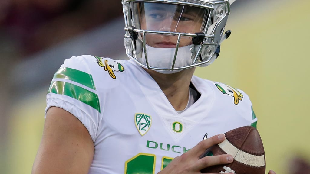 Justin Herbert of the Oregon Ducks runs with the ball in the first