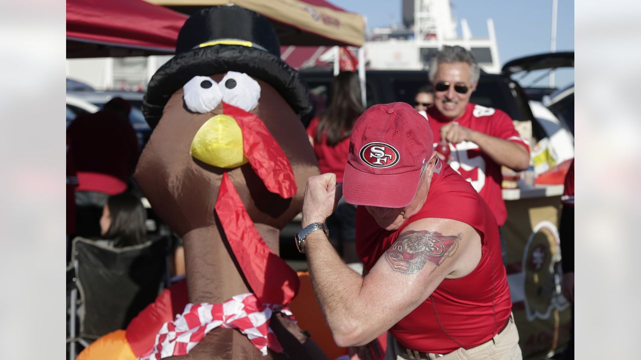 Steve Naylor, right, and his wife Janie, carve a Thanksgiving turkey while  tailgating prior to the Dallas Cowboys and Oakland Raiders game at AT&T  Stadium in Arlington, Texas on November 28, 2013.