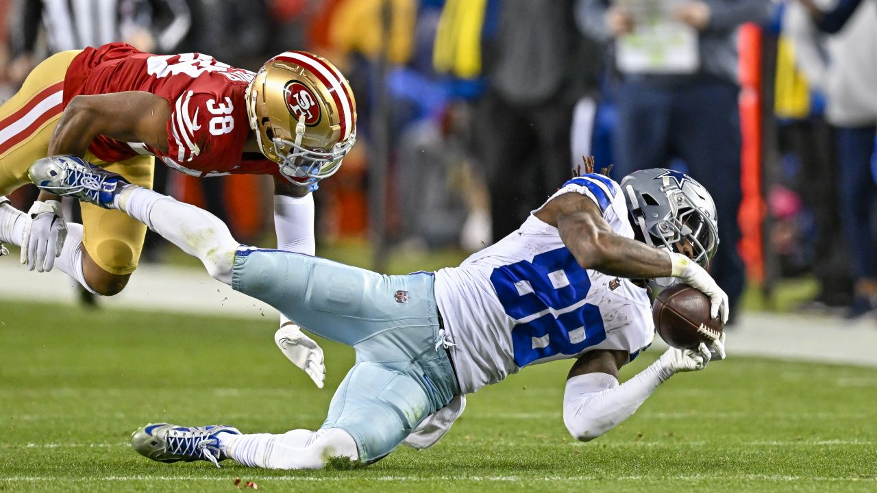 San Francisco 49ers linebacker Fred Warner (54) is tackled by Dallas  Cowboys wide receiver CeeDee Lamb after intercepting a pass during the  first half of an NFL divisional round playoff football game