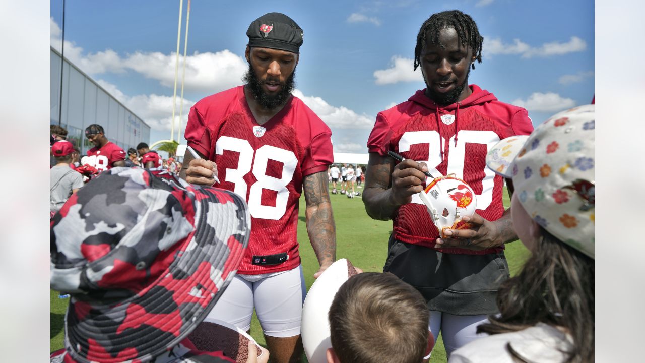 Miami Dolphins running back Raheem Mostert, left, gives autographs to fans  after practice on Back Together Weekend at the NFL football team's  training facility, Sunday, July 30, 2023, in Miami Gardens, Fla. (