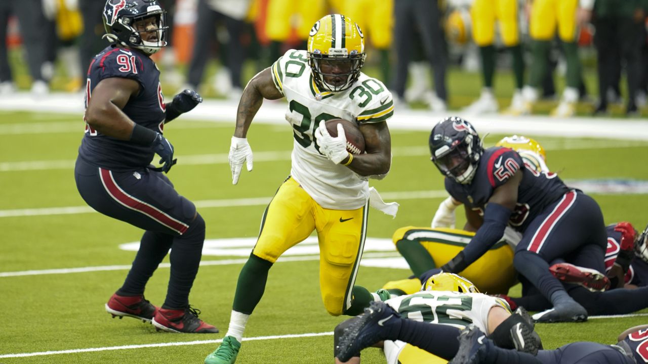 Green Bay Packers running back Jamaal Williams, right, runs with the ball  as Houston Texans defensive end J.J. Watt defends during the first half of  an NFL football game Sunday, Oct. 25