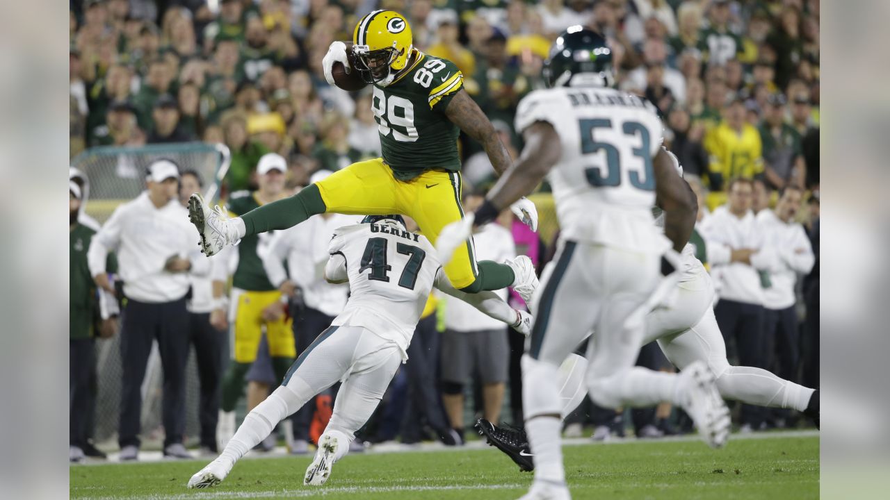 Marcedes Lewis of the Green Bay Packers hurdles Nate Gerry of the