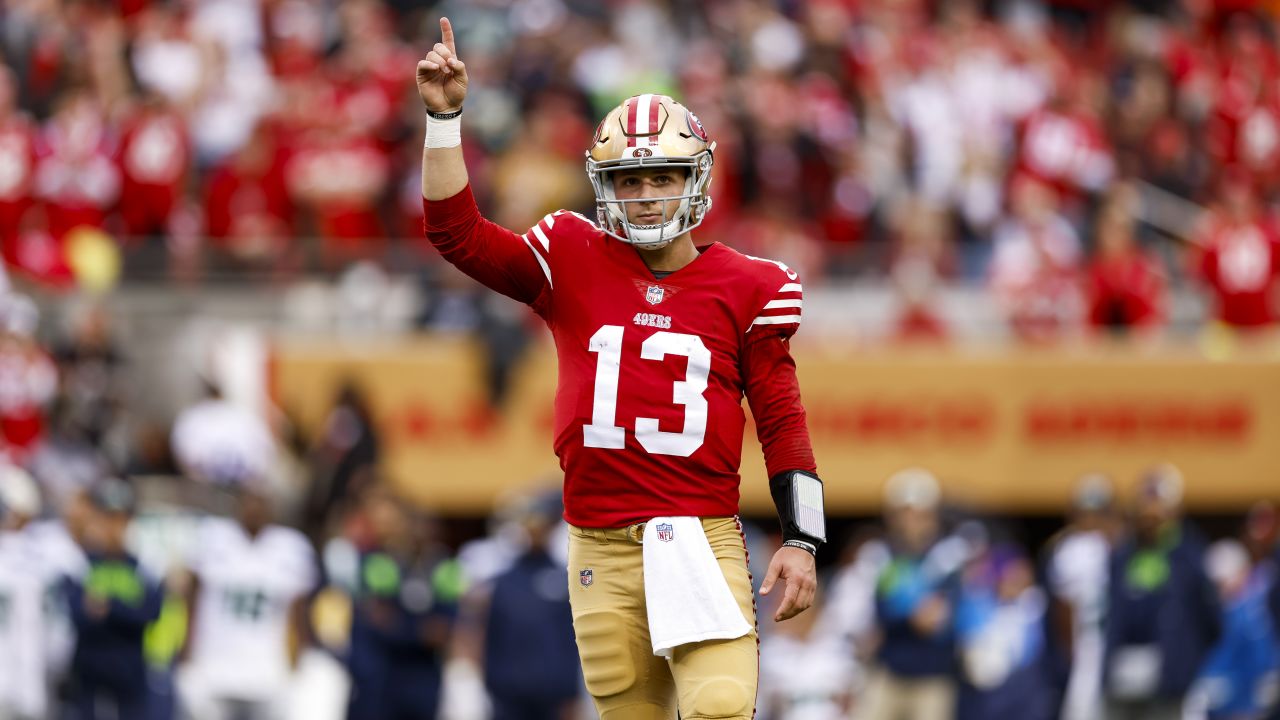 San Francisco 49ers quarterback Brock Purdy (13) gives the football to  guard Aaron Banks (65) to