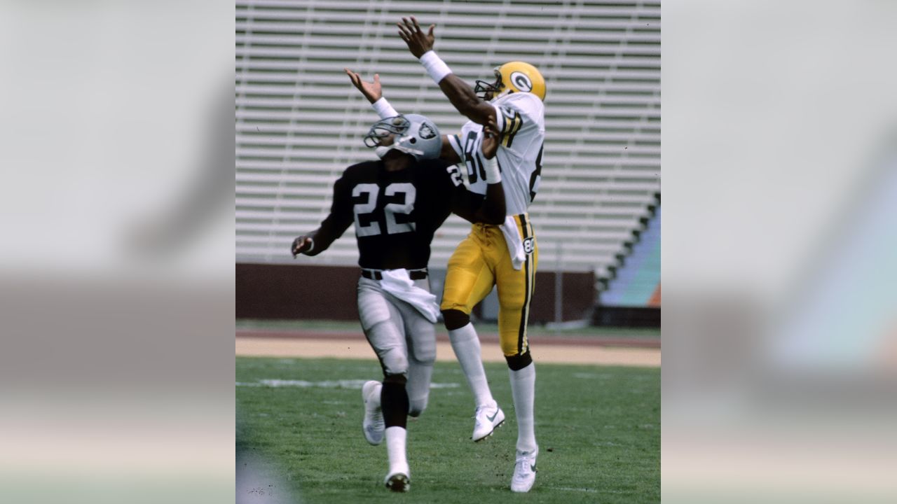 Former Oakland Raiders defensive back Mike Haynes kicks up the sand as he  runs after catching a pass in the NFL Alumni Legends Beach Bowl on Waikiki  Beach Friday, Feb. 4, 2000