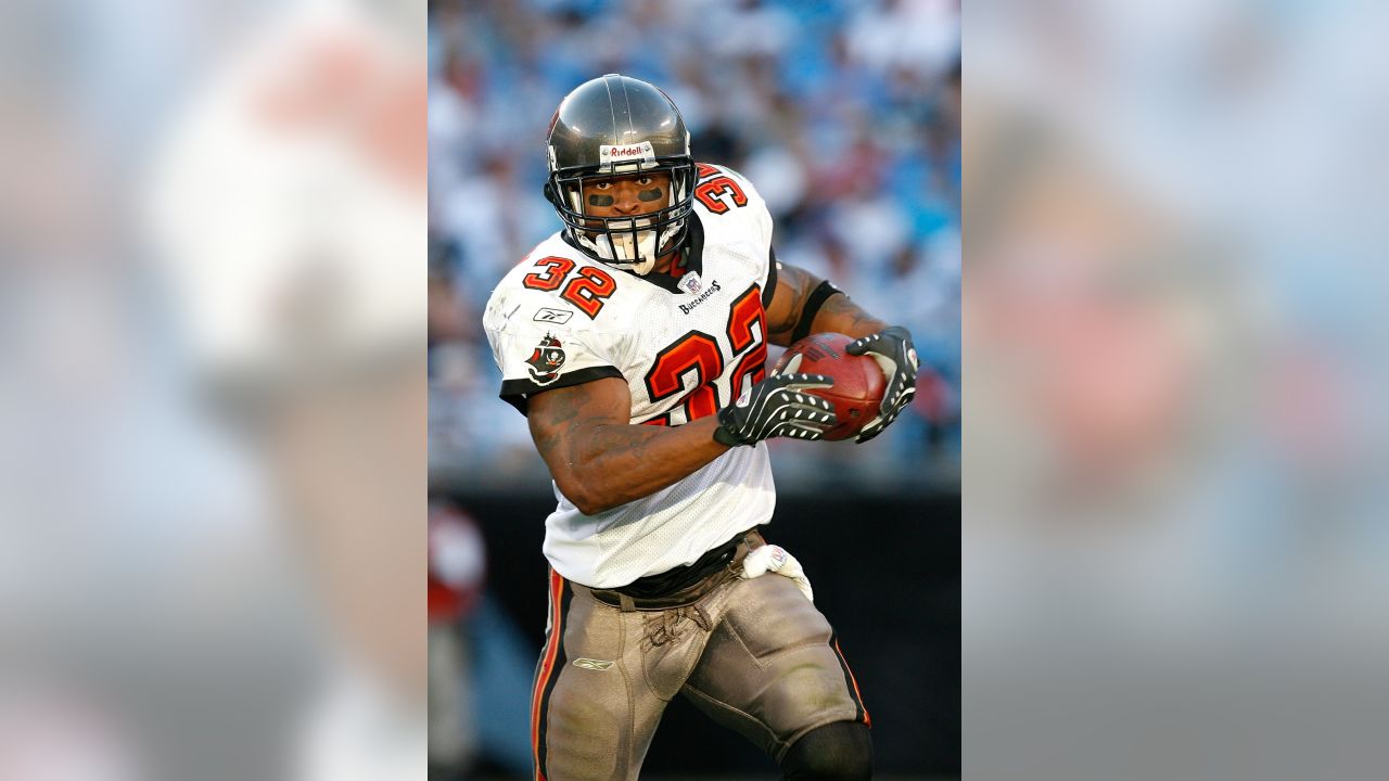 Warrick Dunn of the Atlanta Falcons runs with the ball while pursued