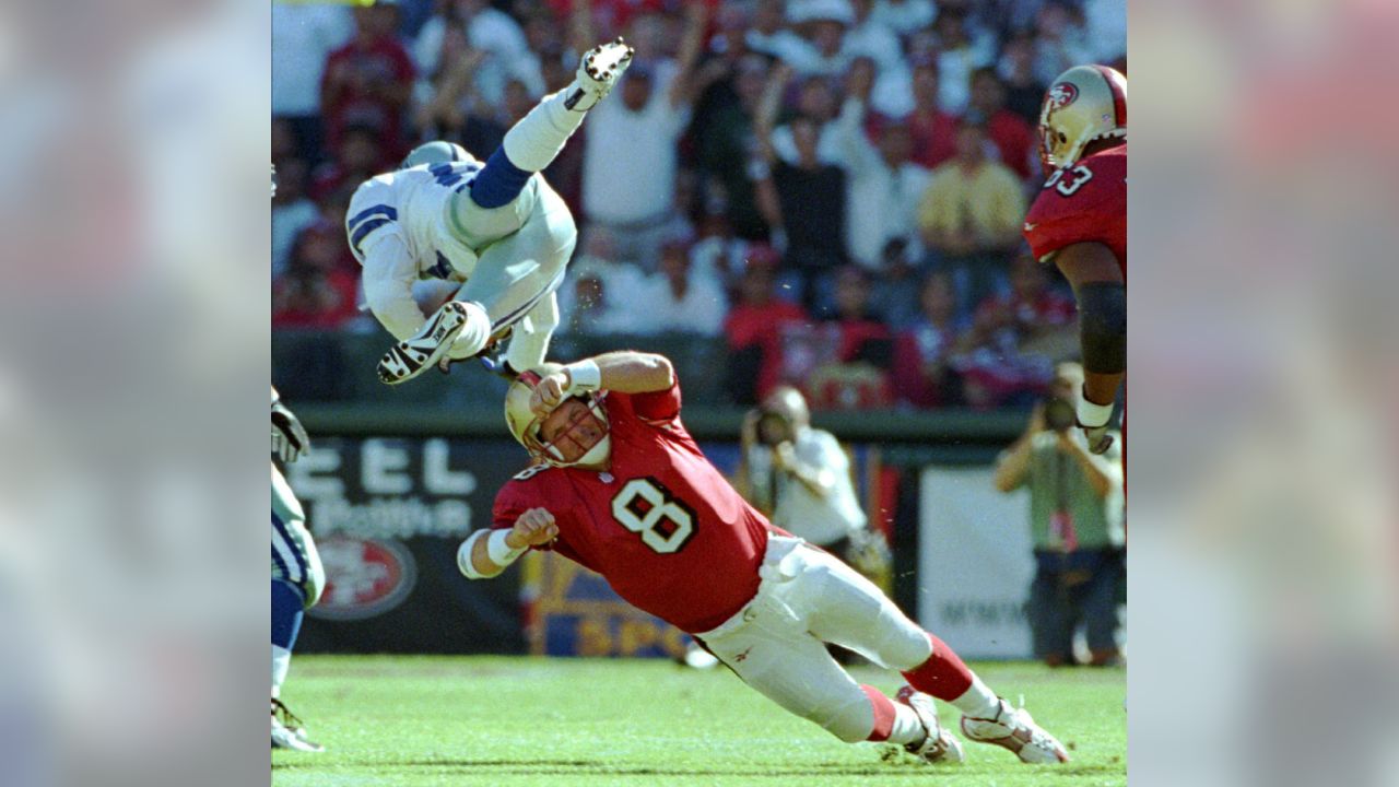 FILE - San Francisco 49ers quarterback Steve Young upends Dallas Cowboys  cornerback Deion Sanders after Sanders intercepted Young in the first  quarter of their Sunday, Nov 2, 1997, game in San Francisco.