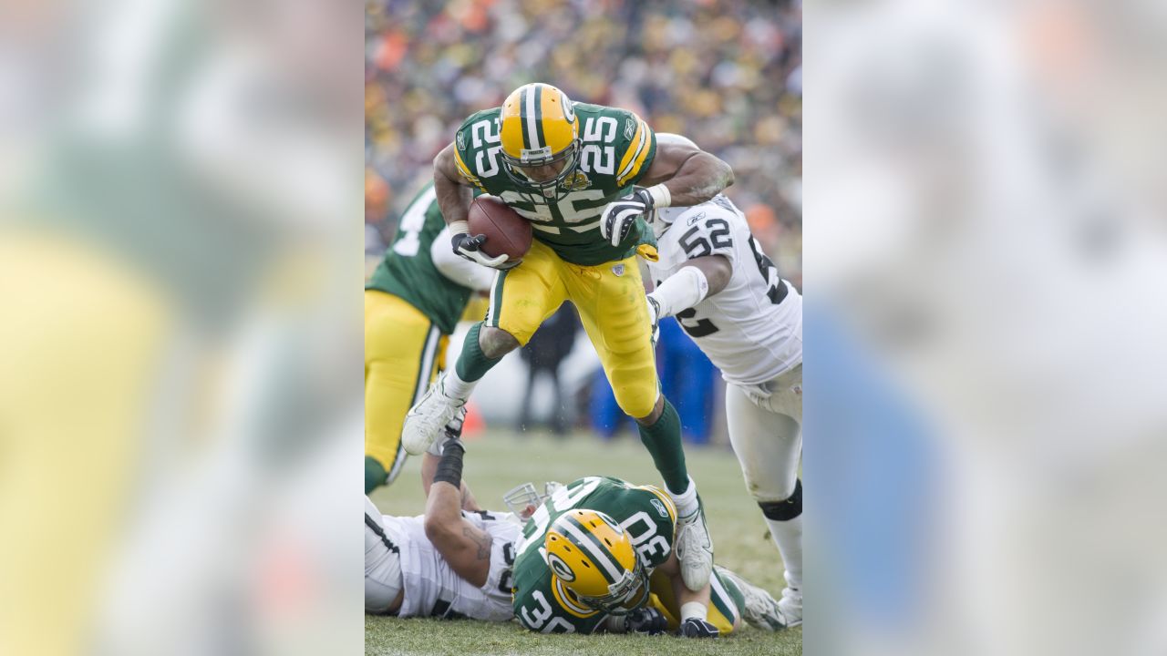 San Francisco 49ers running back Frank Gore (R) runs for a 2-yard gain as  Green Bay Packers inside linebacker A.J. Hawk makes the tackle during the  fourth quarter of the NFC Wildcard