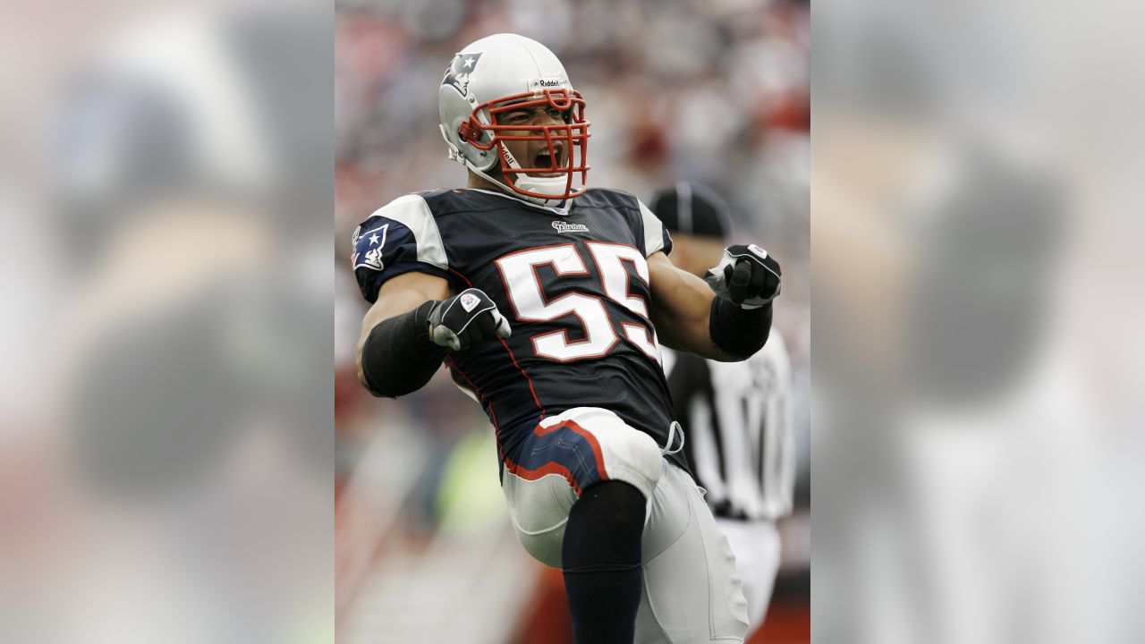 New England Patriots Junior Seau smiles while holding up the Lamar