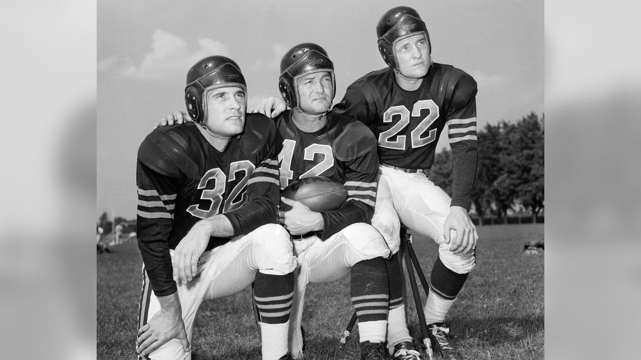 Sid Luckman, left, Chicago Bears' quarterback, gets a hug and a kiss from  teammate George McAfee, center, as Ray McLean, right, watches in the  dressing room following Chicago's defeat of the New