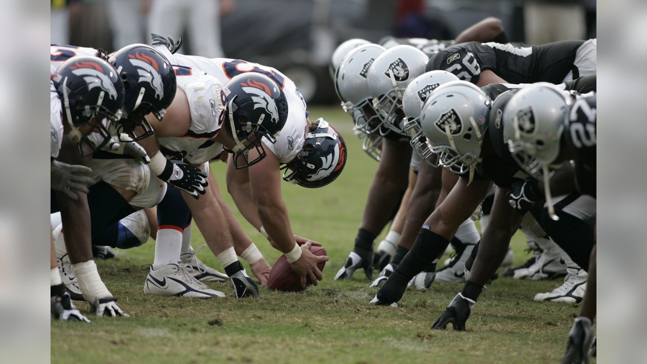 Denver Broncos RB Mike Anderson (38) tries to elude Oakland Raider Kirk  Morrison (52) in the