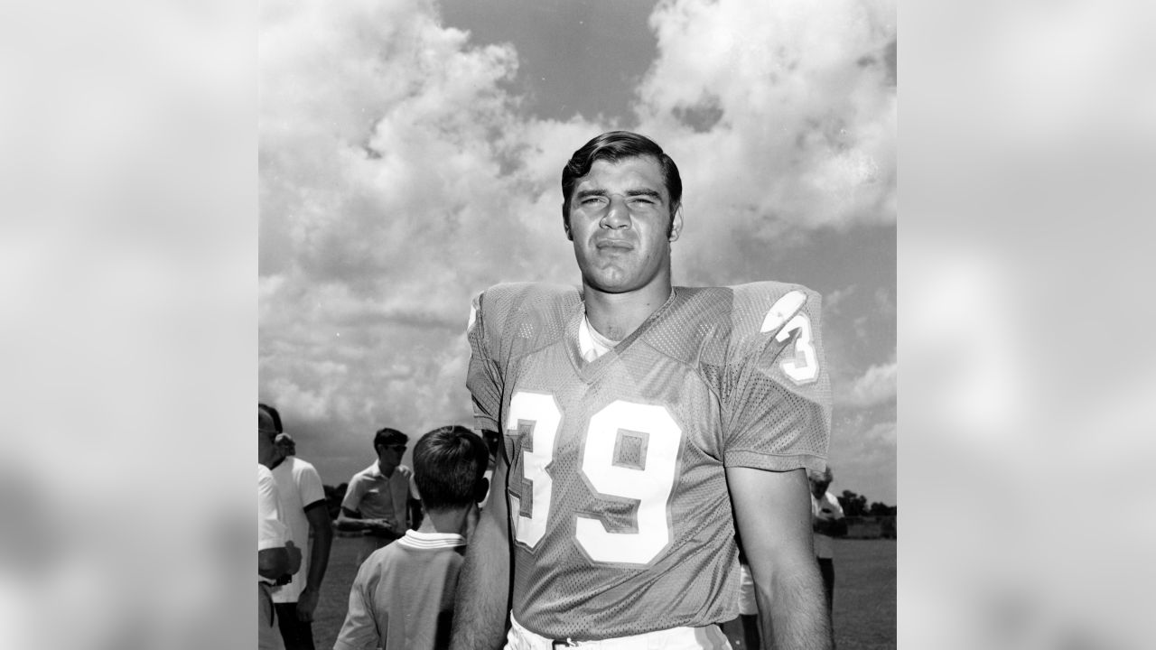 Running back Larry Csonka, in a flowery shirt, listens to ex