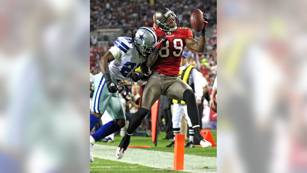 Dallas Cowboys middle linebacker Keith Brooking (51) and Dallas Cowboys  cornerback Orlando Scandrick (32) bring down Tampa Bay Buccaneers tight end  Zack Pianalto (80). The Cowboys defeated the Buccaneers 31-15 in an