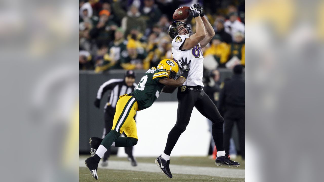 Green Bay Packers' Aaron Rodgers (12) throws with Baltimore Ravens' Kelly  Gregg (97) rushing during the