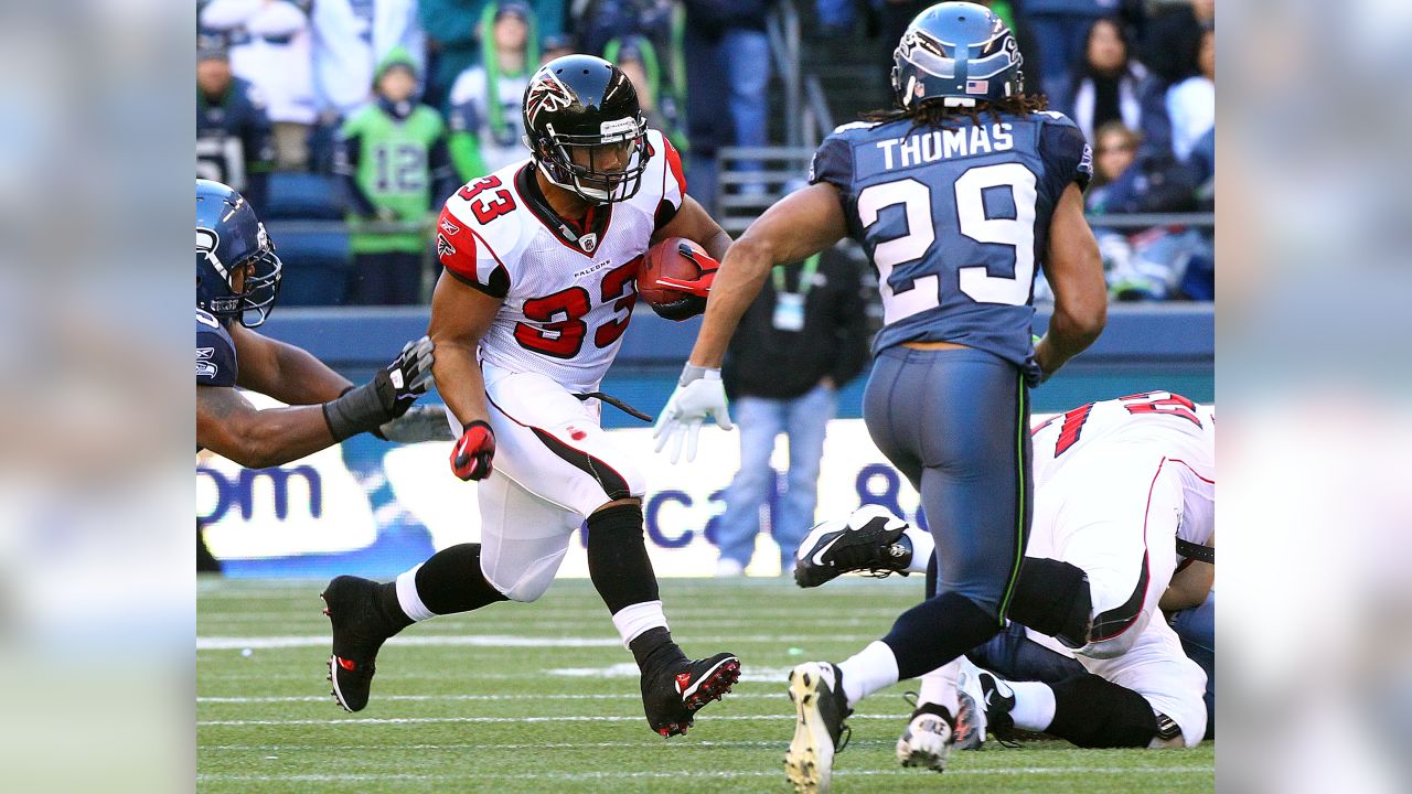 Atlanta Falcons tight end Alge Crumpler (83) is upended by Seattle  Seahawks' Marcus Trufant after a catch for short yardage in the third  quarter of an NFL football game Sunday , Dec.