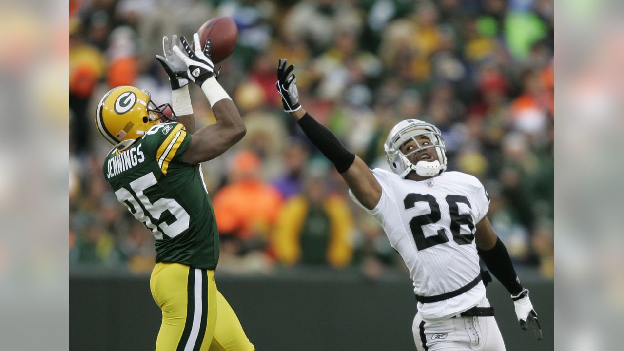 Green Bay Packers wide receiver Greg Jennings is hit by Oakland Raiders  cornerback Stanford Routt (26) and strong safety Tyvon Branch (33) during  an NFL football game Sunday, Dec. 11, 2011, in