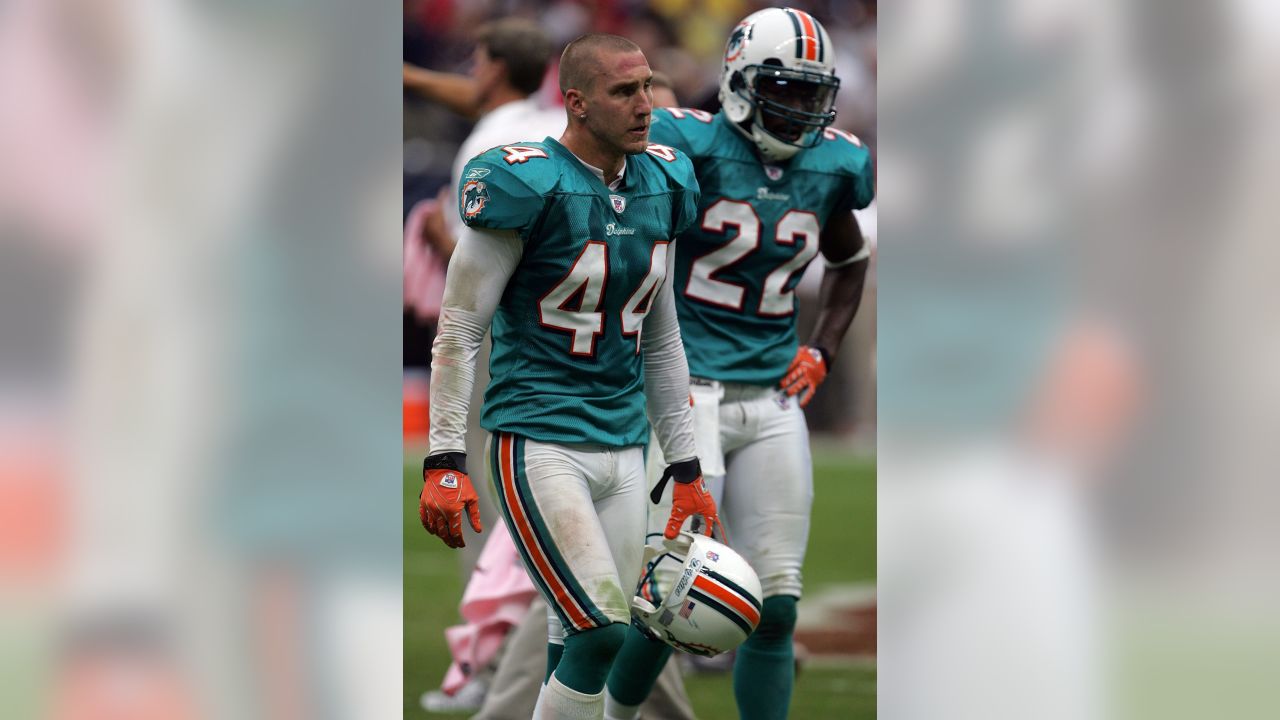 Miami Dolphins players Jason Taylor (99) and Cameron Worrell stop