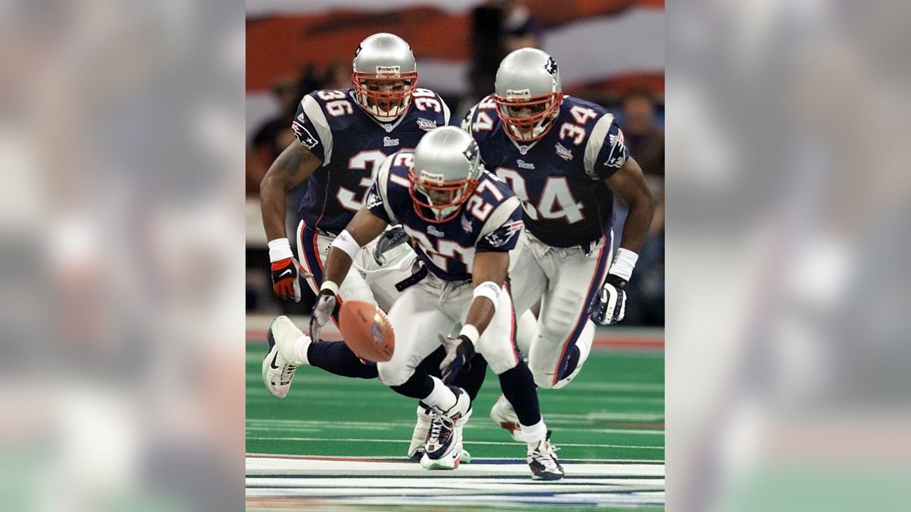 New England Patriots' cornerback Terrell Buckley (27) scoops up a St. Louis  Rams fumble in front of Patriots' Lawyer Milloy (36) and Tebucky Jones (34)  in Super Bowl XXXVI Sunday, Feb. 3