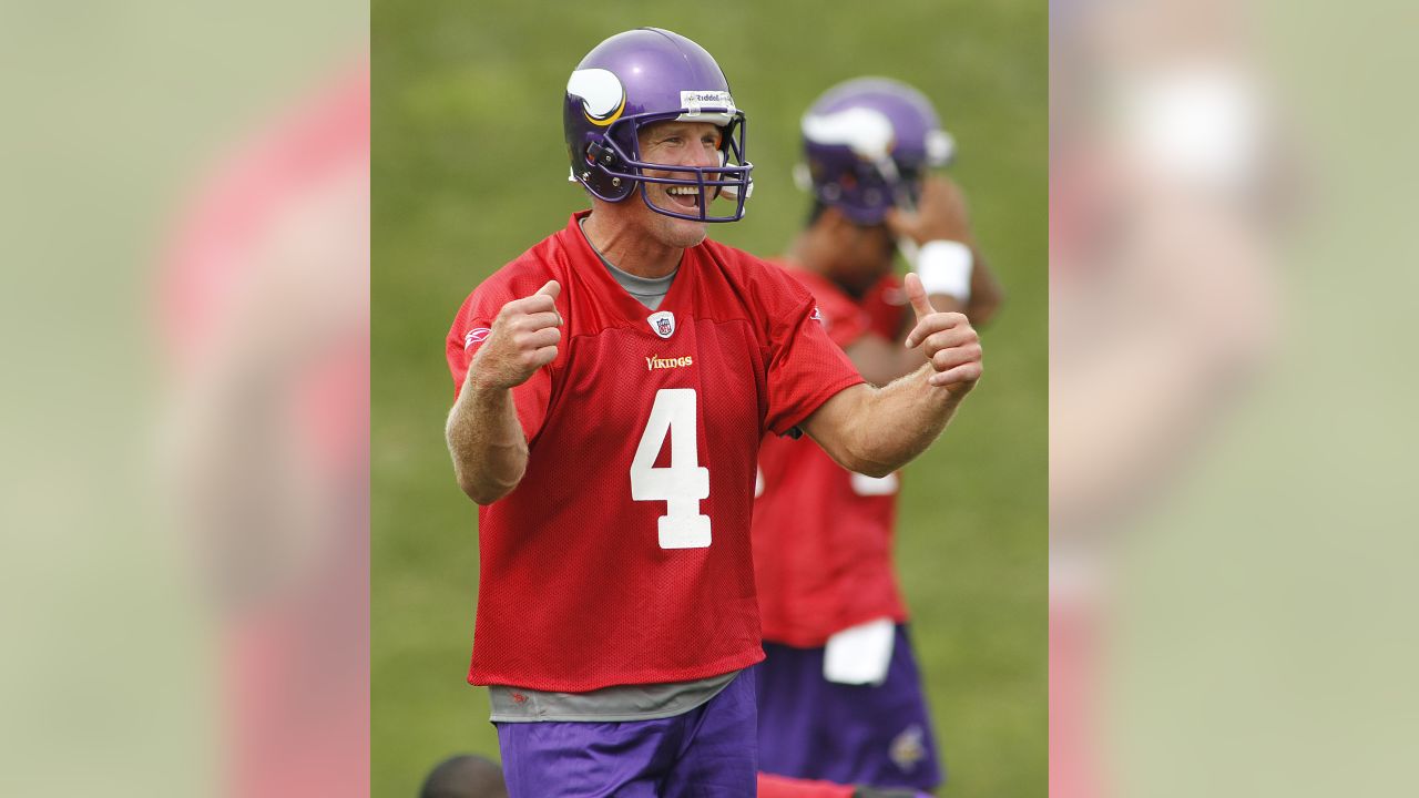 A ballboy lobs a ball as Minnesota Vikings quarterbacks Tarvaris Jackson,  left, rookie Joe Webb, center and Sage Rosenfels, right, head to another  practice field at the NFL team's football training camp