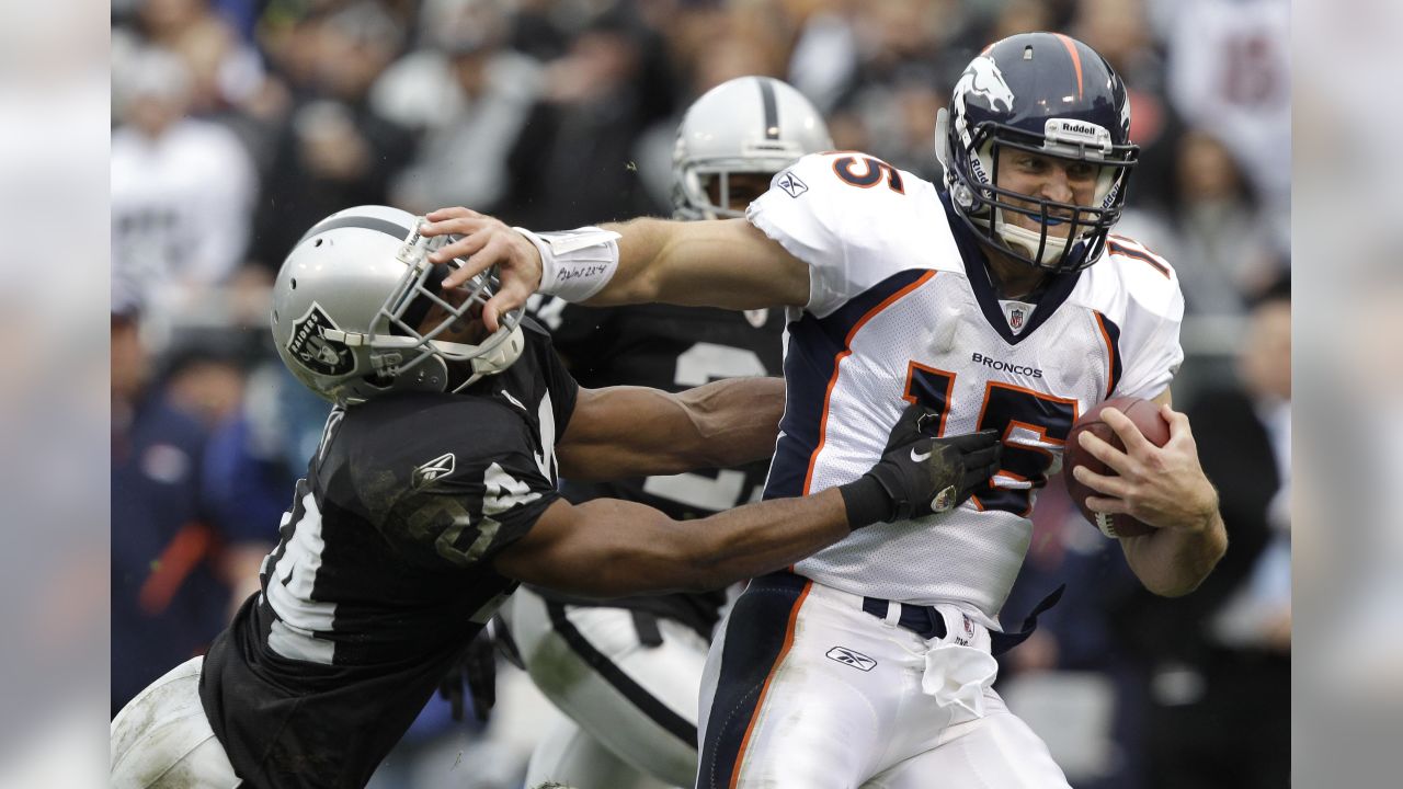 Denver Broncos RB Mike Anderson (38) tries to elude Oakland Raider Kirk  Morrison (52) in the