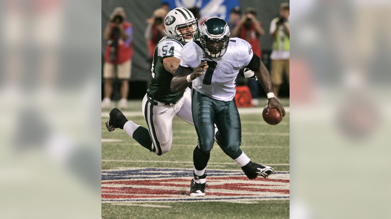 Philadelphia Eagles' Michael Vick (7) evades New York Jets linebacker Bart  Scott (57) during the first quarter of an NFL preseason football game at  Giants Stadium, Thursday, Sept. 3, 2009, in East