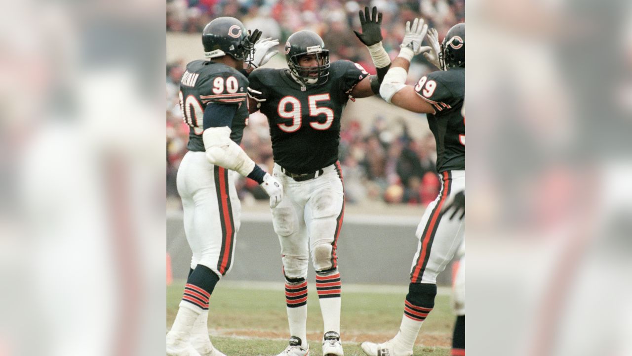 Chicago Bears' Richard Dent carries the Super Bowl Trophy as the