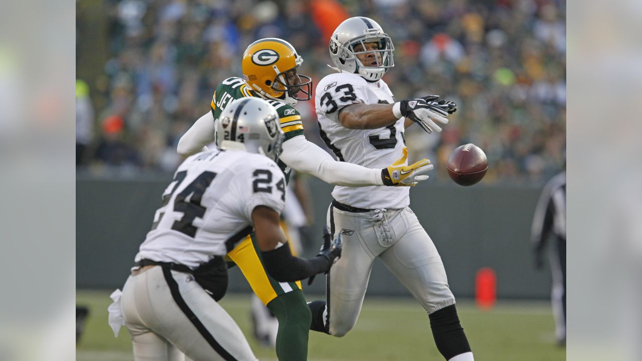 Green Bay Packers wide receiver Greg Jennings is hit by Oakland Raiders  cornerback Stanford Routt (26) and strong safety Tyvon Branch (33) during  an NFL football game Sunday, Dec. 11, 2011, in