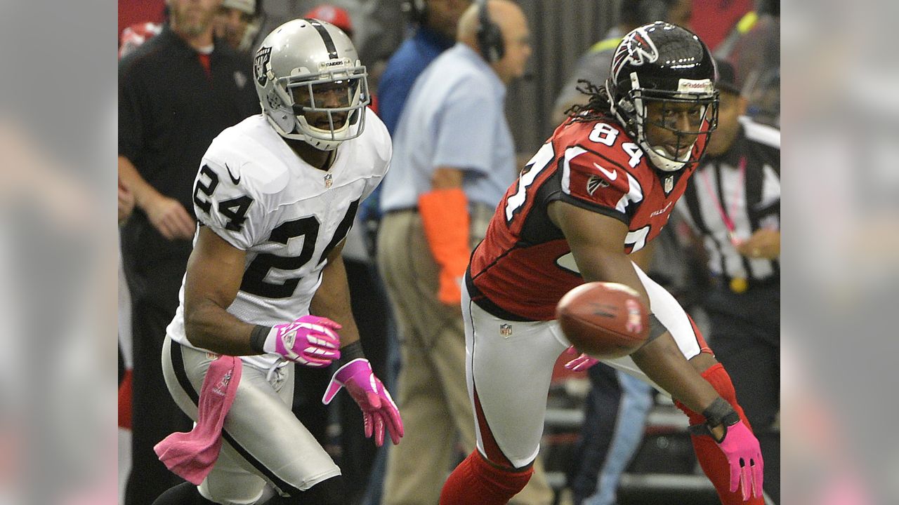 Atlanta Falcons wide receiver Roddy White (84) pulls defender Oakland  Raiders cornerback Michael Huff (24) during