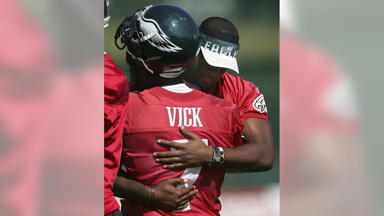 Philadelphia Eagles quarterback Michael Vick's daughter Jada Vick, 6, left,  tries to take her father's helmet off her sister London Vick, 3, after an  NFL football training camp practice at Lehigh University