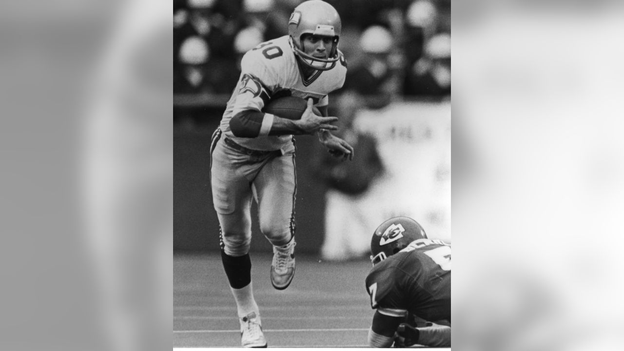 Seattle Seahawks receiver Steve Largent (80), center, holds the ball after  catching a touchdown pass from Dave Krieg in the first quarter of the game  against the Los Angeles Raiders in Seattle