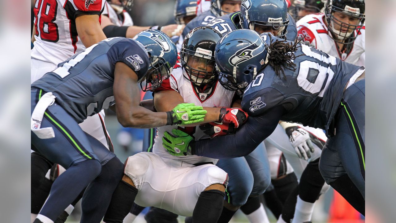 Atlanta Falcons tight end Alge Crumpler (83) is upended by Seattle  Seahawks' Marcus Trufant after a catch for short yardage in the third  quarter of an NFL football game Sunday , Dec.