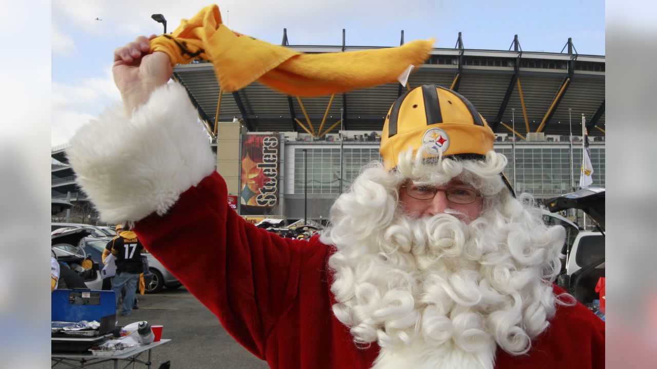 Jake Denooy of Fort Collins, Colo., places a Denver Broncos flag to top off  a Christmas tree while he tailgates before the Oakland Raiders face the  Broncos in the first quarter of