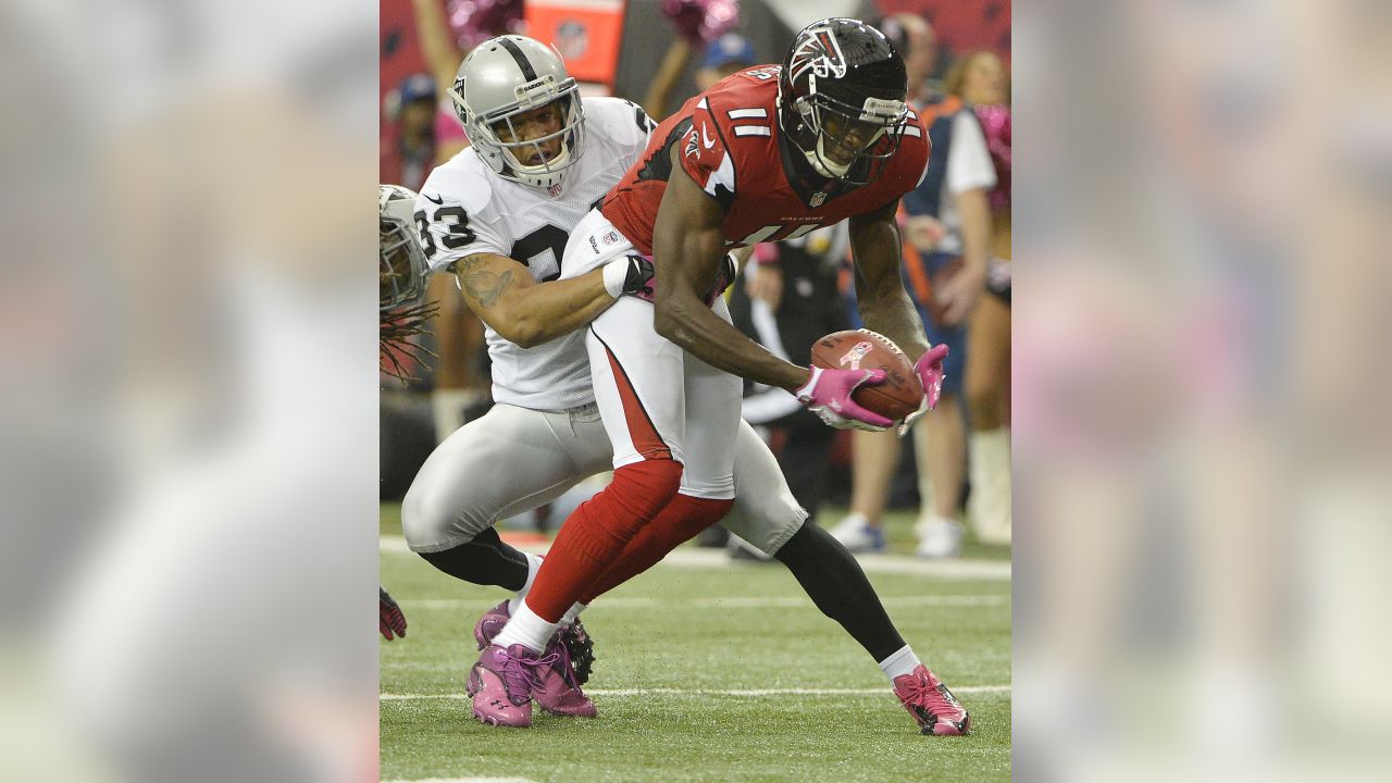 Atlanta Falcons wide receiver Roddy White (84) pulls defender Oakland  Raiders cornerback Michael Huff (24) during