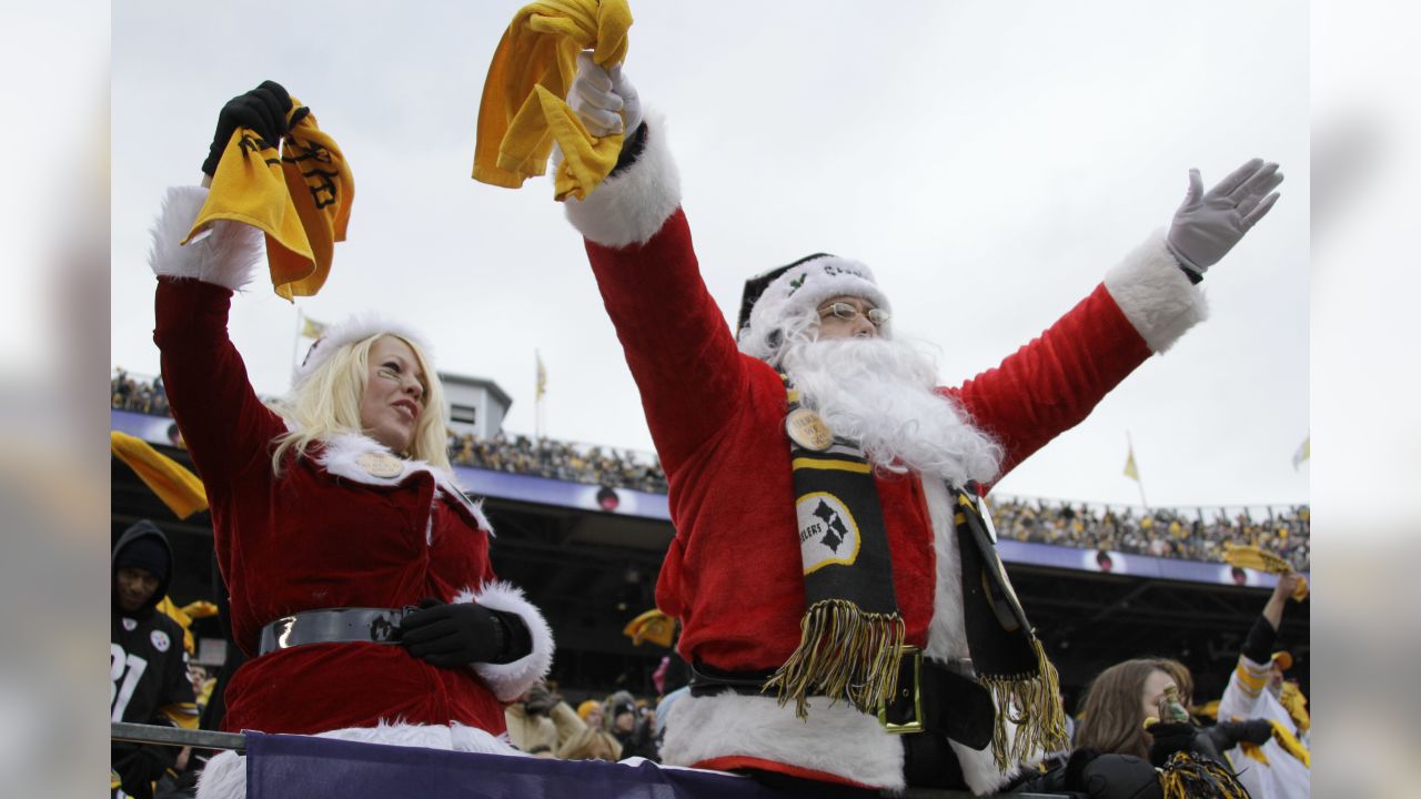 Jake Denooy of Fort Collins, Colo., places a Denver Broncos flag to top off  a Christmas tree while he tailgates before the Oakland Raiders face the  Broncos in the first quarter of