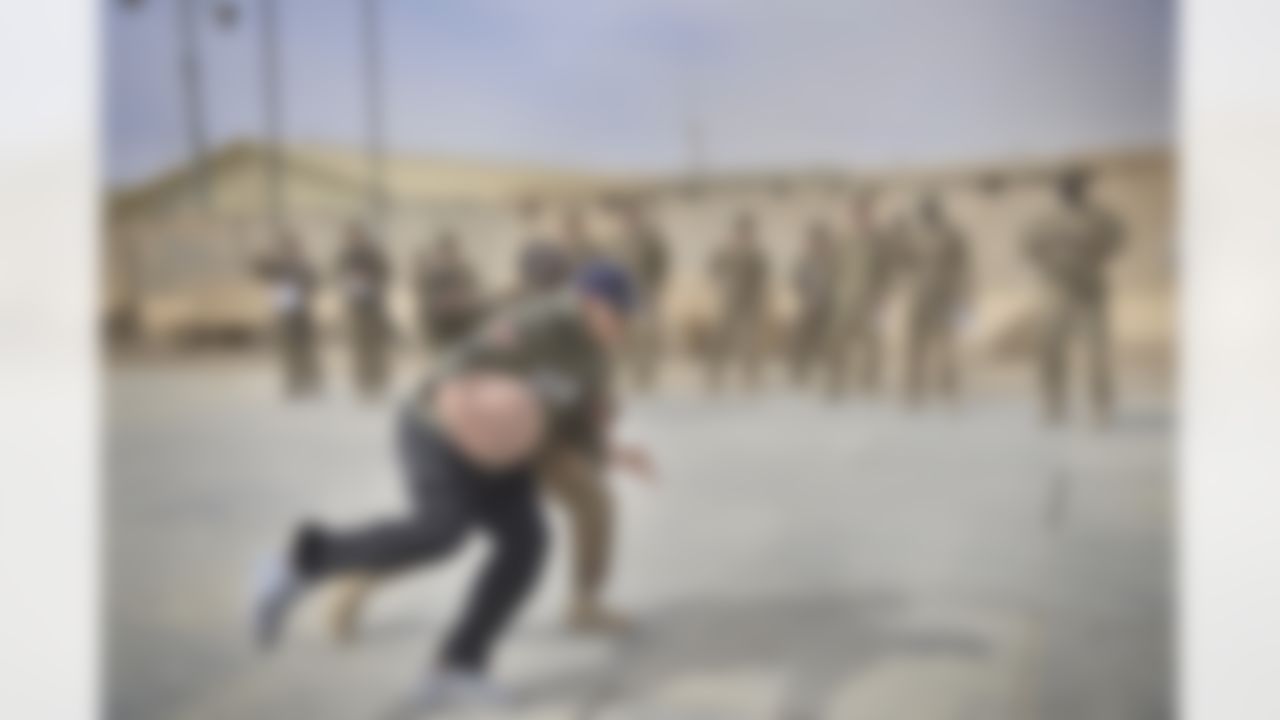On the second day of his USO/NFL tour to the Middle East, Jimmy Graham of the New Orleans Saints trades in his football for a chance to play basketball one-on-one with a soldier as fellow troops watch on March 5, 2014. Graham is joined by Pierre Garcon of the Washington Redskins and Brandon Fields of the Miami Dolphins, who are all in the region to help the USO make �Every Moment Count� with troops. (USO Photo by Dave Gatley)