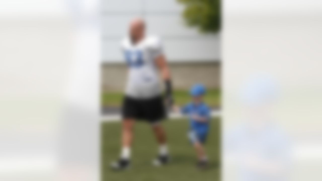 Detroit Lions defensive end Kyle Vanden Bosch walks onto the training camp field with 4-year-old Trevor Stewart at the Detroit Lions training camp facility in Allen Park, Mich., Sunday, Aug. 1, 2010. (AP Photo/Carlos Osorio)