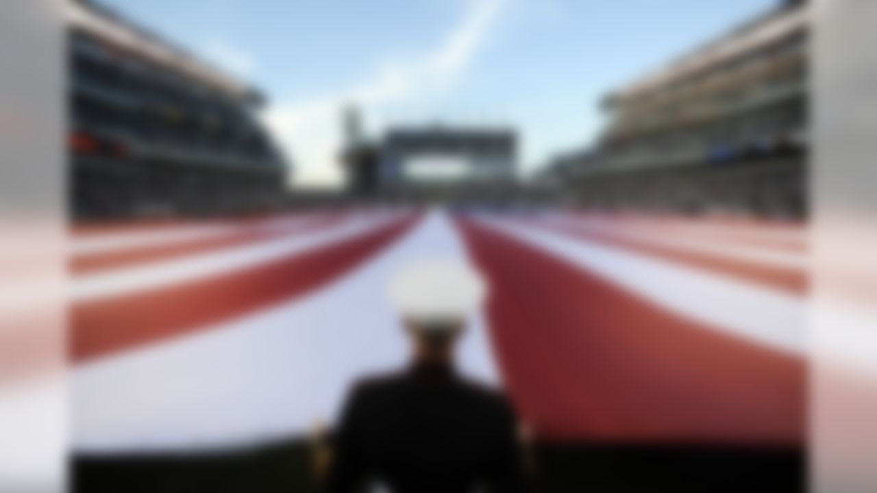A Marine helps hold a U.S. flag during the pregame ceremonies before a game between the Philadelphia Eagles and the Dallas Cowboys in Philadelphia. (AP Photo/Michael Perez)