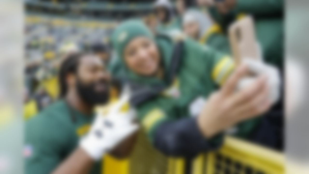 Green Bay Packers' Za'Darius Smith smiles for a selfie with a fan before an NFL football game against the Carolina Panthers Sunday, Nov. 10, 2019, in Green Bay, Wis. (AP Photo/Mike Roemer)