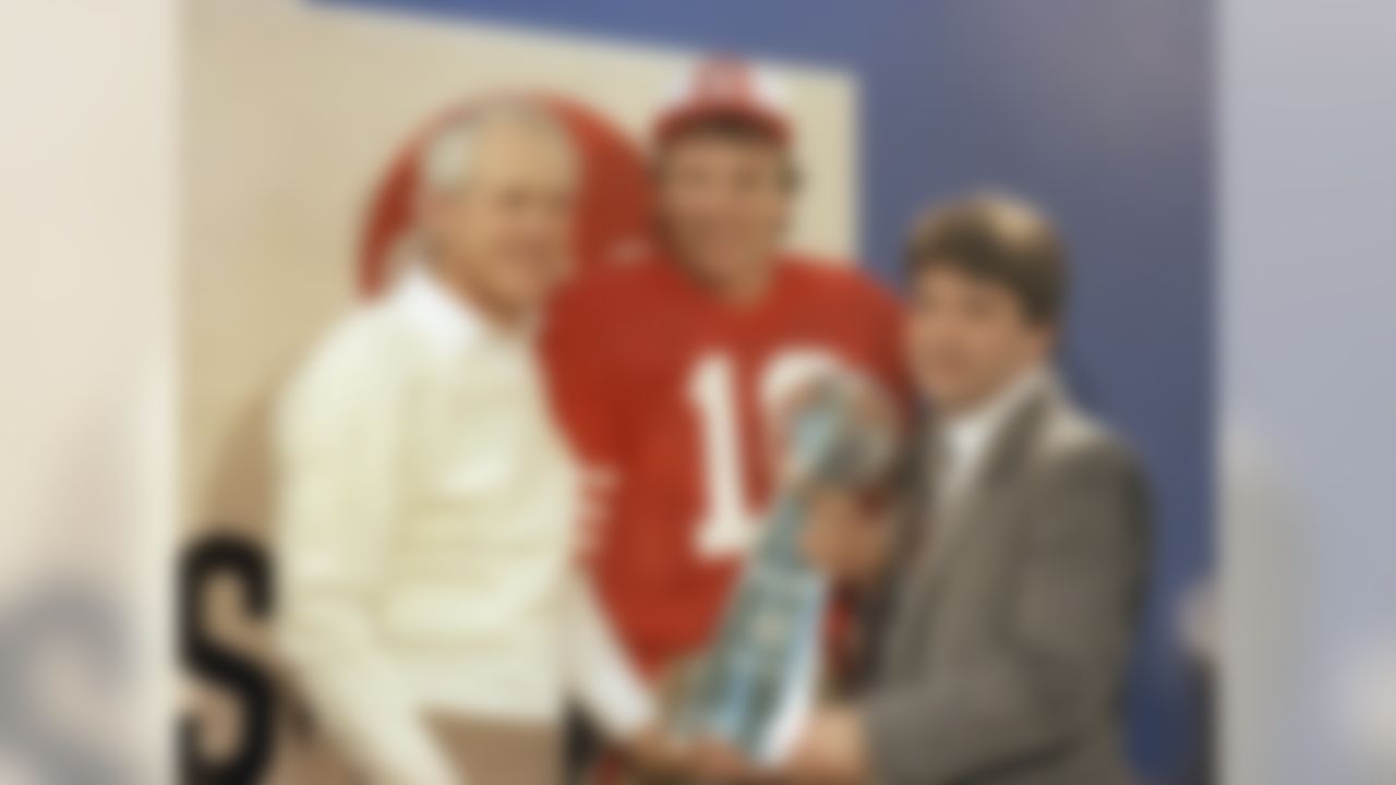 San Francisco 49ers' quarterback Joe Montana (16) holds the Lombardi Super Bowl trophy with coach Bill Walsh and 49ers' owner Edward DeBartolo, Jr. following the Super Bowl XIX at Stanford Stadium in Stanford, CA on January 20, 1985.  (Associated Press)