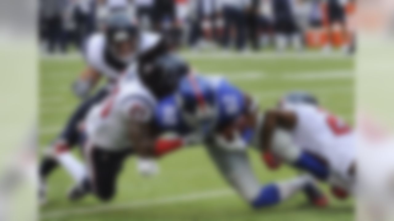 New York Giants cornerback Jayron Hosley (28) is tackled by Houston Texans free safety Kendrick Lewis (21) and cornerback Johnathan Joseph (24) in the first quarter of an NFL football game, Sunday, Sept. 21, 2014, in East Rutherford, N.J. (AP Photo/Bill Kostroun)